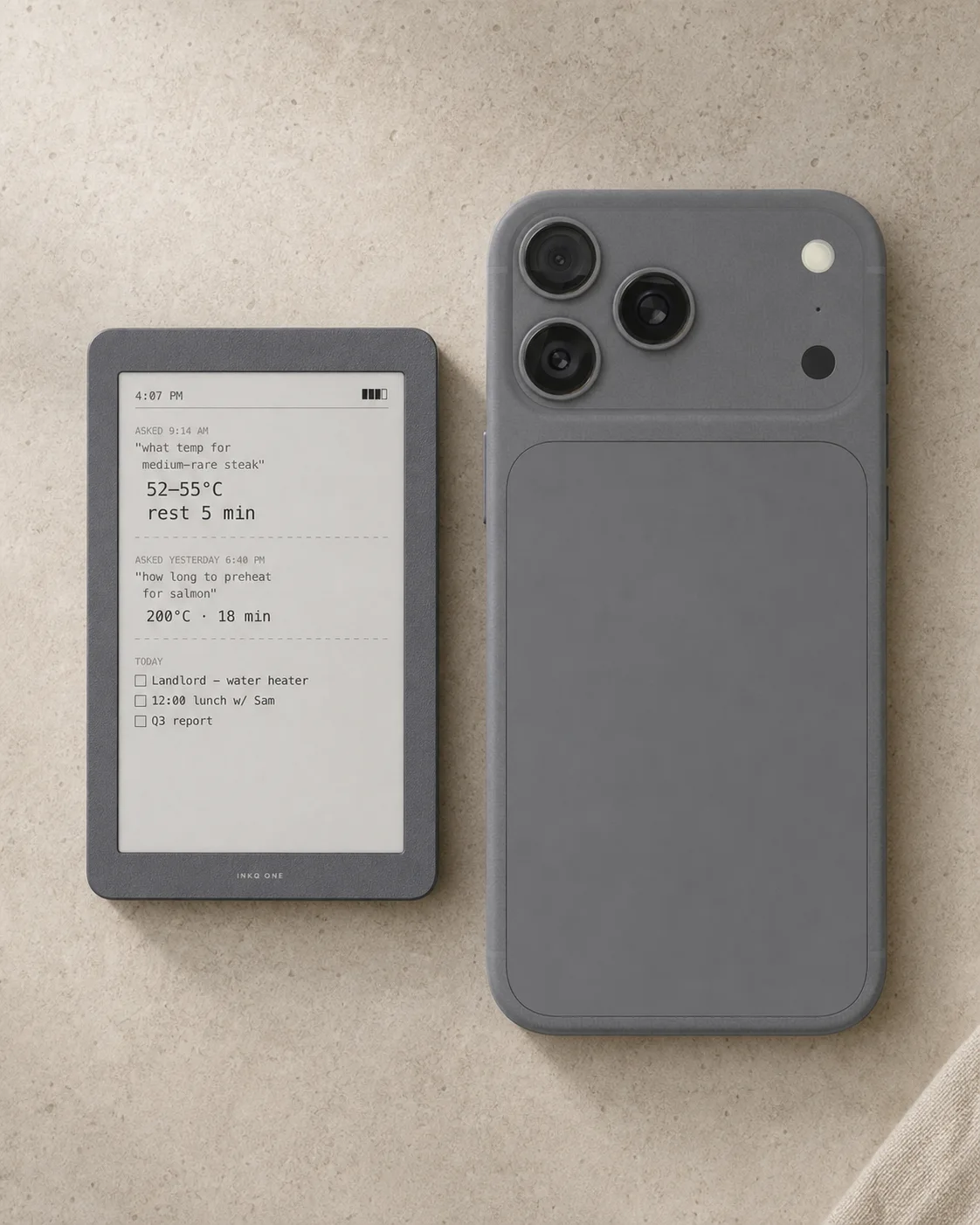 Size comparison concept of INKQ One beside a phone on a pale limestone surface